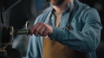 Man smell coffee beans roasted check quality roasting machine roaster Caucasian guy male technologist barista in apron smelling flavor fresh roast caffeine working in factory business owner industry video