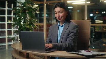 ásia coreano chinês japonês empresária digitando usando computador portátil computador conectados o negócio mulher fêmea menina senhora dentro escritório trabalhador mostrando gesto polegar acima aprovar Boa Gerente Empregador recomendar gostar video