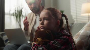 Caucasian family trouble at home father working online remote distant on couch with laptop ignoring angry talking to upset lonely daughter with toy child kid girl work life imbalance childhood sadness video