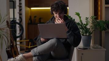 Smiling Caucasian guy using laptop at home man chatting online social media hipster typing computer user male developer salesman surfing Internet remote working freelance ordering delivery application video