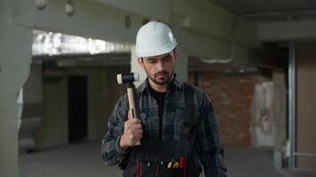 Caucasian man builder engineer in hard hat holding hammer check tool beat helmet safety on construction site building protection architect foreman repair work industrial handyman looking at camera video
