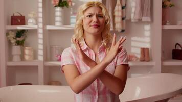 Caucasian teen girl woman female in candy pink home bathroom crossed hands arms cross not stop gesture disagreement deny rejection refusing looking at camera negative attitude shaking head no ban video