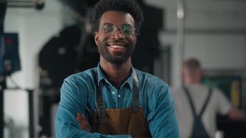 Confident happy smiling African American man worker in coffee roasting fabric crossing hands joyful smile work with roasted cocoa looking at camera indoors male guy professional working distribution video