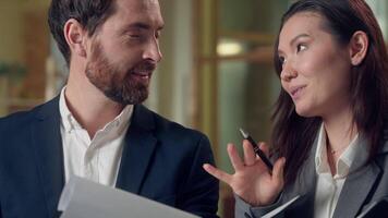 Multiethnic business team Korean businesswoman explaining idea gesturing convincing smiling Caucasian businessman listening agreement pen teamwork discussion success strategy office folder clipboard video