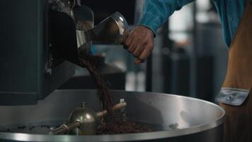 African American guy male man worker in coffee roasted fabric industry working with roasting machine pressing pushing lever mixing flow beans cocoa grain organic production small business owner work video