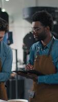 African American Caucasian men examining coffee beans texture smell document observations small business quality speak inspection aroma control roasted product espresso factory roasting process work video