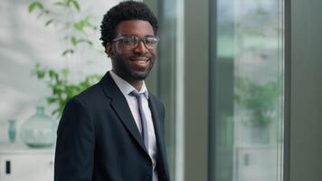 African American man business guy male businessman looking in window smiling at camera portrait in office employer manager company CEO investor indoors smile success ethnic entrepreneur satisfied video