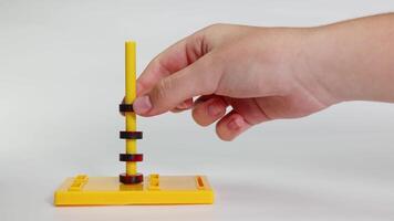 Hands interact with magnetic rings on a stand, demonstrating attraction and repulsion in a controlled environment video