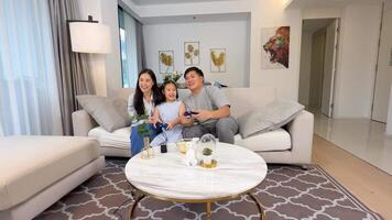 A family enjoys playing games together in a bright, modern living room, creating a joyful and relaxed atmosphere video