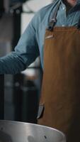 Caucasian man worker in coffee roasted fabric industry working stand near roasting machine with cacao beans mixing talking mobile phone call male small business owner talk communicate with smartphone video