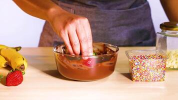 Dipping strawberries in chocolate with sprinkles video