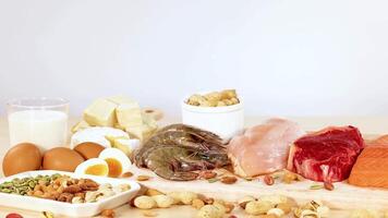 A variety of protein-rich foods including nuts, eggs, dairy, and meats are neatly arranged on a table video