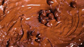 Chocolate chips being mixed into smooth batter video