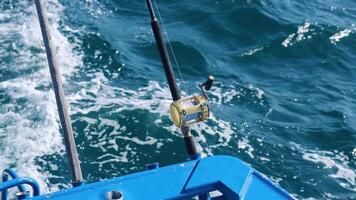 Fishing rods on a boat in Phuket's ocean, capturing dynamic water movement under bright sunlight video
