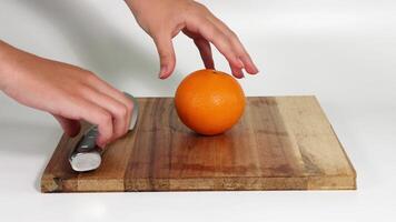 Hands slicing an orange with a knife video