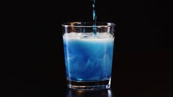 Blue drink poured, creating bubbles and foam video