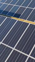 Sunlit solar panels arranged in rows on a farm, captured from an aerial perspective with dynamic shadows video