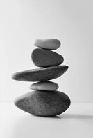 A monochrome image showcasing a stack of five smooth stones balanced on top of each other photo
