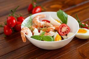 Delicious seafood salad with egg and basil close-up photo