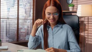 Caucasian business woman analyzing data information diagram paperwork writing notes looking laptop satisfied good job result happy businesswoman smiling female working with papers documents at table photo
