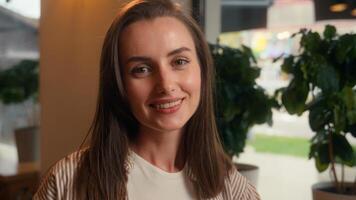 Portrait happy smiling carefree cheerful Caucasian woman relaxing in cafe girl female cafeteria visitor enjoying resting posing in restaurant looking at camera smile indoors customer client headshot photo