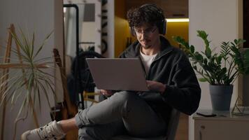 Focused Hispanic guy hipster user holding laptop purchasing delivery at home freelancer developer type man trader search information online Internet male work remote computer tech shopping cyberspace photo