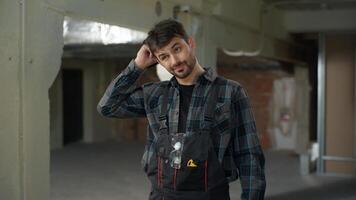Man builder engineer on construction site working rubbing head thoughtful male Caucasian guy architect handyman foreman in uniform start work building technician electrician repairman industrial job photo