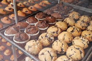 Muffins and cupcakes displayed in a bakery case photo