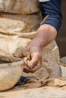 detail of traditional pottery making process, artist preparing material pottery on a wheel photo