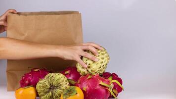 Hands placing fruit into a bag video