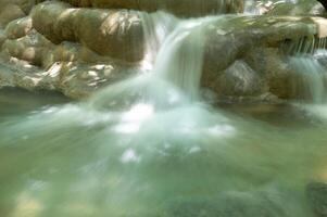 waterfall in the jungle with lush green trees photo