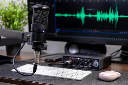 Professional microphone, audio interface, and computer screen with waveform for home studio podcasting, digital audio recording, and online content creation photo