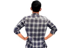 Back view of a young man in a plaid shirt against a plain white background, thoughtful posture photo
