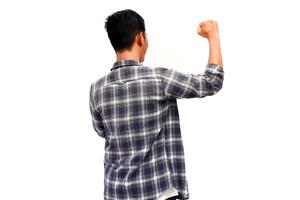 Rear view of an Asian man in a plaid shirt with raised arm, expressing success against white background photo
