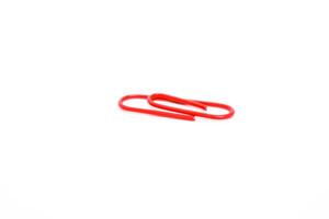 Close-up of a Red Paper Clip on a White Background, Symbolizing Organization and Office Supplies photo