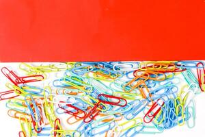 A Colorful Collection of Paper Clips Against a Red Background photo