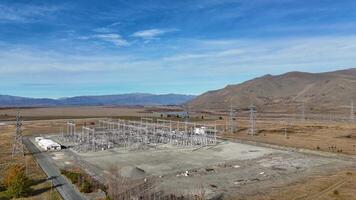Aerial footage of a power substation at Lake Tekapo, New Zealand, showcasing high-voltage infrastructure against a mountainous autumn landscape video