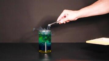 A beaker with dry ice creates a smoky reaction, showcasing a chemical experiment in a controlled environment video