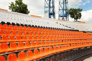 a section of a stadium with rows of plastic seats. Ideal for use in articles about sports venues, event planning, or urban infrastructure photo