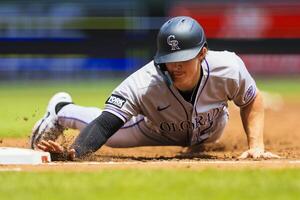 Colorado Rockies designated hitter Mickey Moniak (22) slides into first in the third inning against the Cincinnati Reds at Great American Ball Park. editorial_image