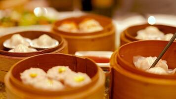 Chopsticks pick dim sum from bamboo steamers in a warm, inviting restaurant setting with soft lighting video