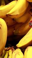 Close-up of ripe bananas in a supermarket. Bright lighting highlights the vibrant yellow color and freshness video