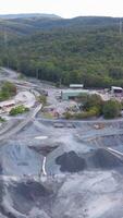 Drone footage captures a quarry in Gold Coast, Australia, showcasing industrial activity amidst lush greenery under natural lighting video