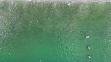 Drone footage captures boats and beachgoers at Patong Beach, Phuket, showcasing vibrant ocean colors and lively atmosphere video