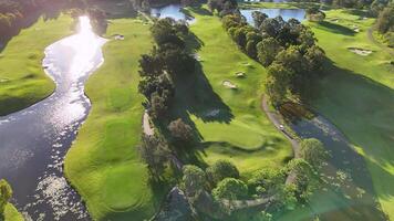 Drone captures serene golf course landscape with lush greens and water features during golden hour on the Gold Coast video