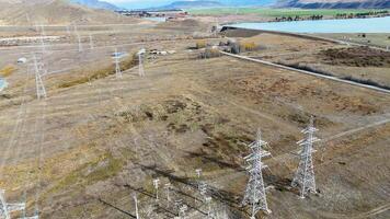 Drone captures expansive view of power lines and substation in New Zealand's rugged landscape under clear skies video