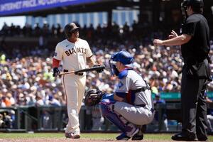 San Francisco Giants designated hitter Rafael Devers (left) questions home plate umpire John Bacon after a pitch he thought was ball four was called strike two during the sixth inning against the Los Angeles Dodgers at Oracle Park. editorial_image