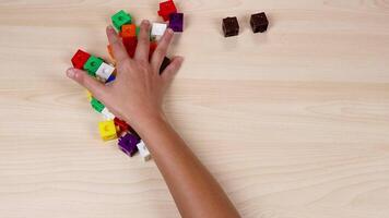 Hands organize colorful cubes on a wooden table video