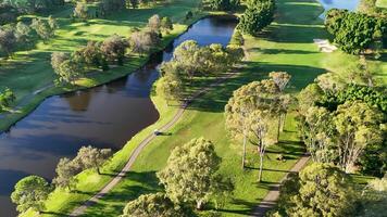 Drone footage captures a lush golf course with water features and greenery under bright sunlight in Gold Coast, Australia video