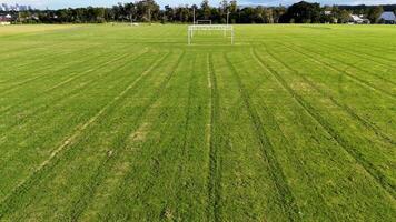 Aerial view of a soccer field in Gold Coast, Australia. The drone captures the field's green expanse and goalposts under clear skies video